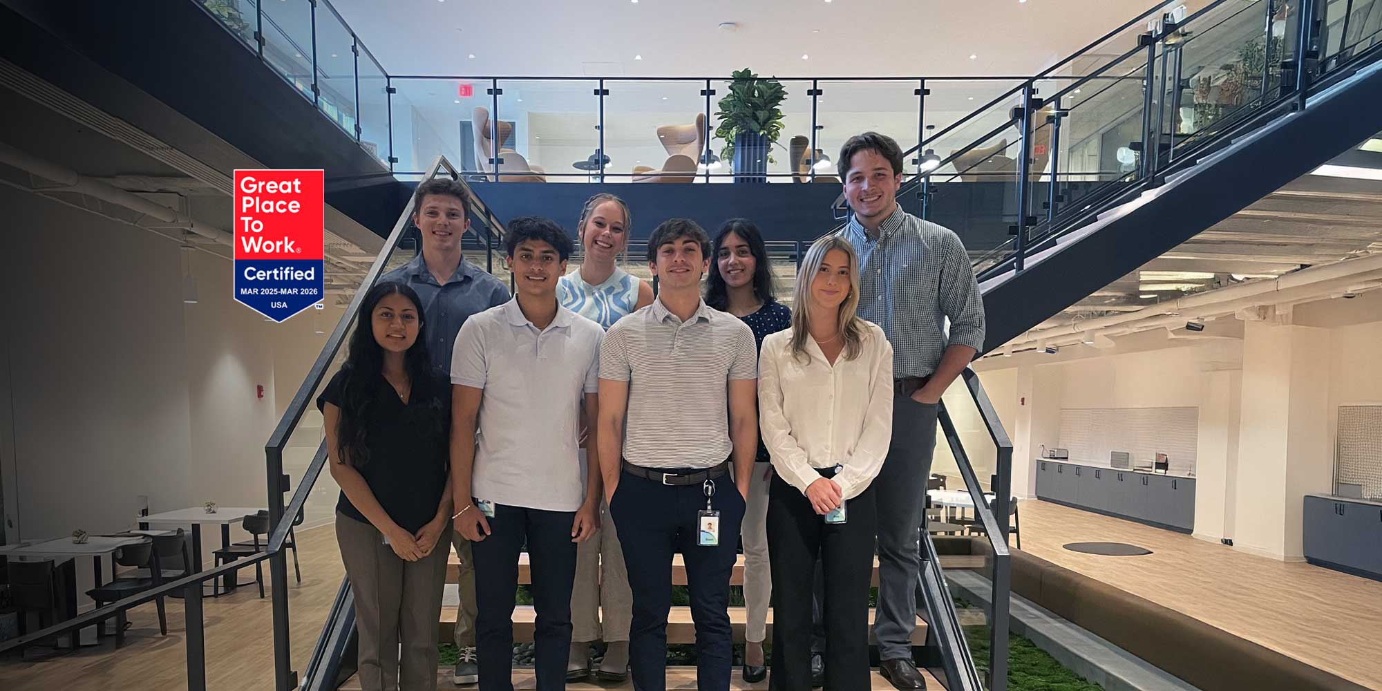 8 Smiling CCU interns standing on stairs