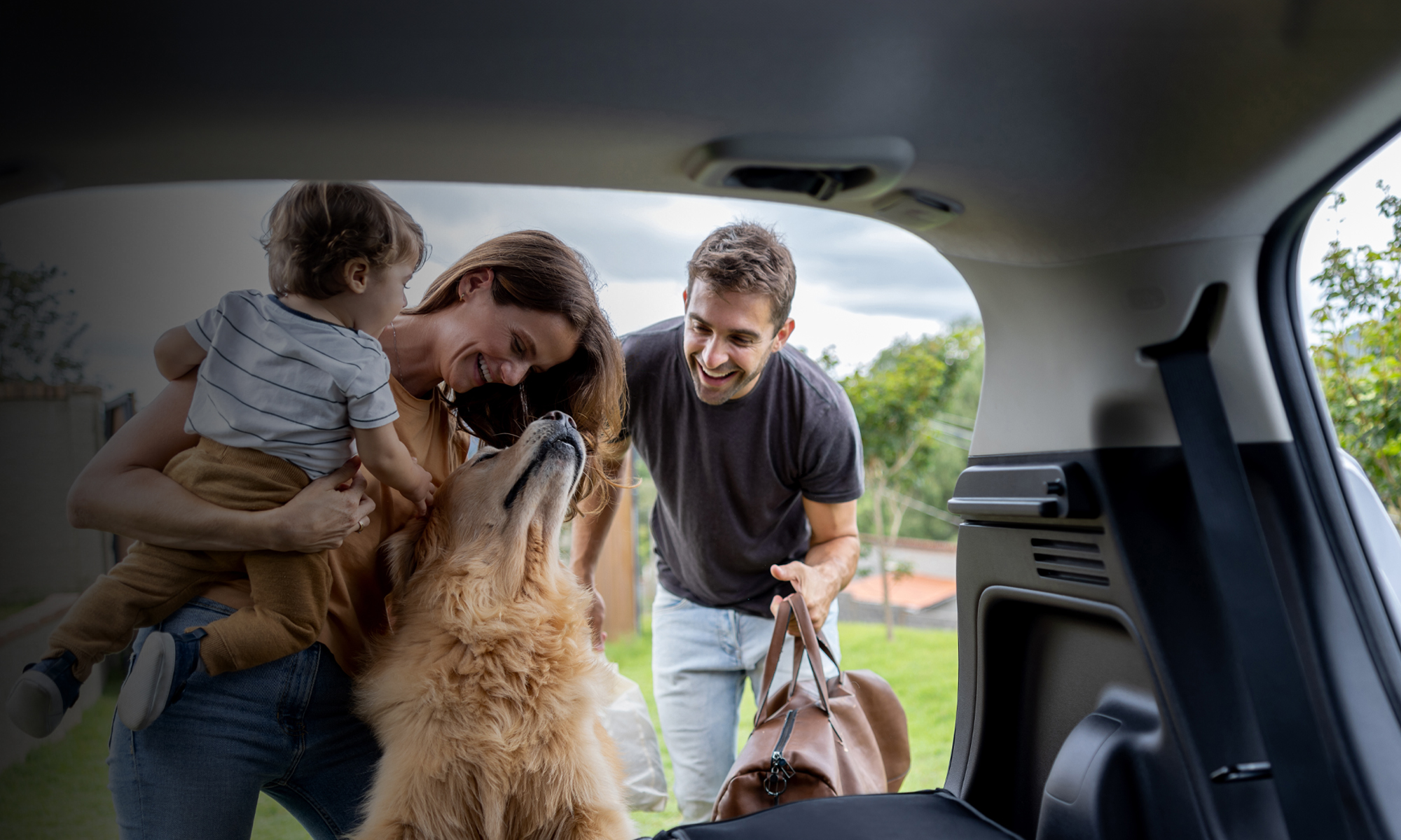 Family reaching in tailgate of truck with a dog